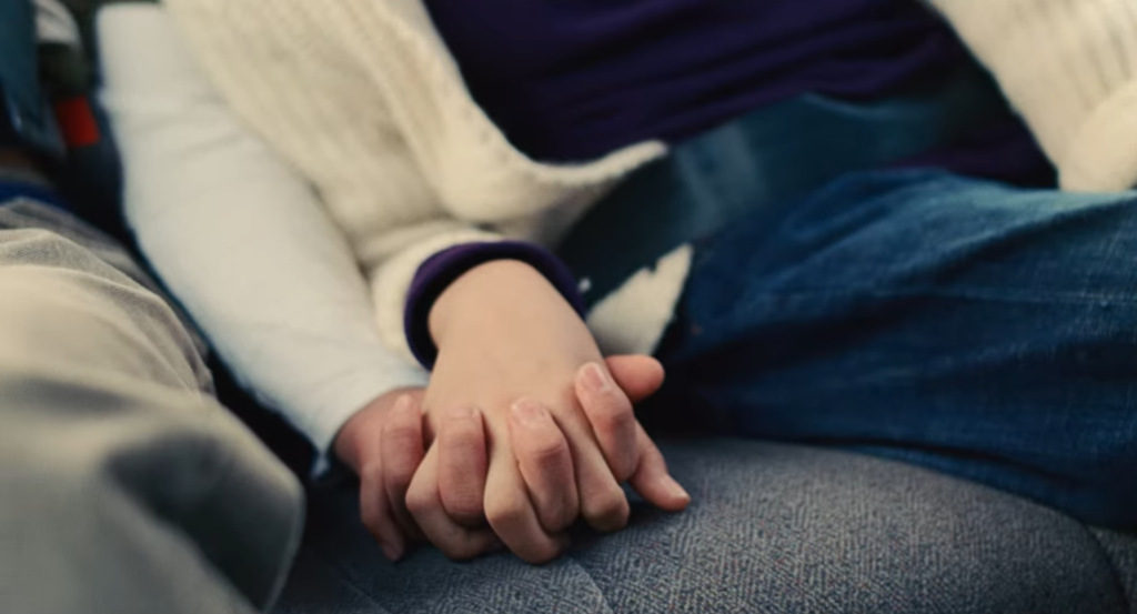 Close-up of the young Nora and Hae Sung holding hands.